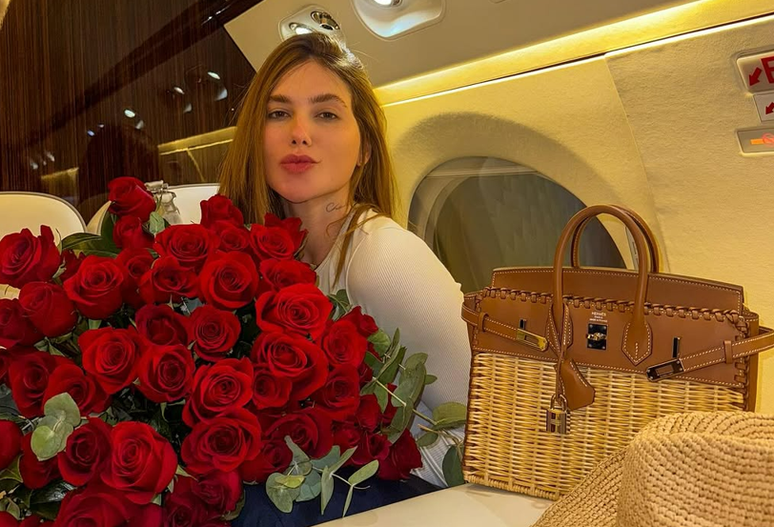 Virginia ganha flores e deixa a Espanha com bolsa grifada de mais de R$ 400 mil