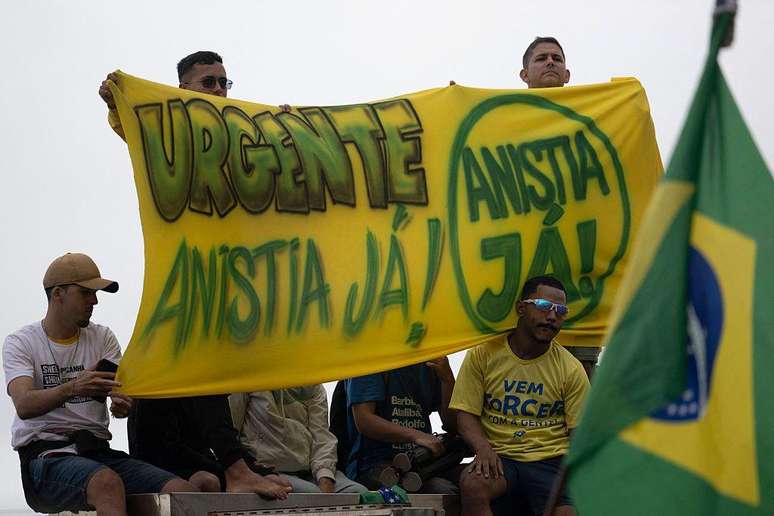 Apoiadores de Bolsonaro seguram uma faixa com os dizeres "Urgente, anistia j&aacute;" em manifesta&ccedil;&atilde;o na praia de Copacabana, no Rio de Janeiro