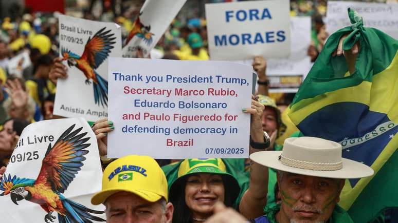Mulher segura cartaz agradecendo Trump, Marco Rubio, Eduardo Bolsonaro e Paulo Figueredo por "defender a democracia no Brasil"