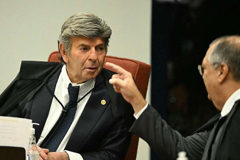 O ministro Luiz Fux (E) do Supremo Tribunal Federal (STF) ouve o colega Flavio Dino durante a sess&atilde;o de vota&ccedil;&atilde;o para condenar ou absolver o ex-presidente de extrema direita (2019-2022) Jair Bolsonaro em um julgamento de golpe, em Bras&iacute;lia, em 9 de setembro de 2025