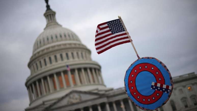 Bandeira com o símbolo do movimento QAnon, carregada por apoiadores de Donald Trump, 6 de janeiro de 2021, em Washington.