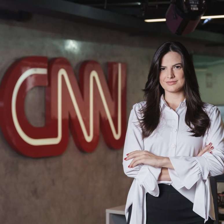 Marina Demori, jornalista posa com logo da CNN ao fundo
