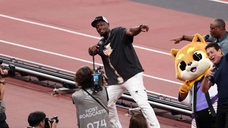 O velocista jamaicano aposentado Usain Bolt mostra sua icônica pose de comemoração do raio para a multidão no segundo dia do Campeonato Mundial de Atletismo de Tóquio 2025 no Estádio Nacional em 14 de setembro de 2025 em Tóquio, Japão.