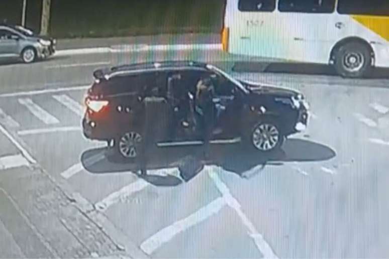 Os criminosos entram de volta no carro para fugir.
