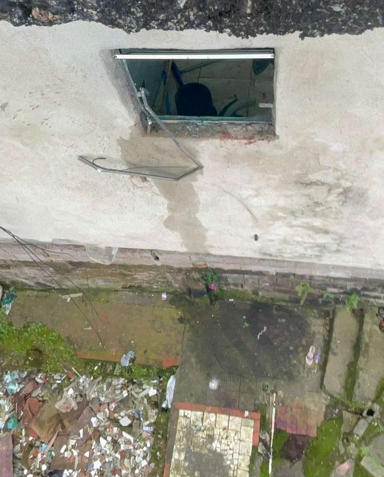Janela do banheiro que Evandrou estourou para pular nu de uma altura de sete metros. No chão, tomou mais tiros.