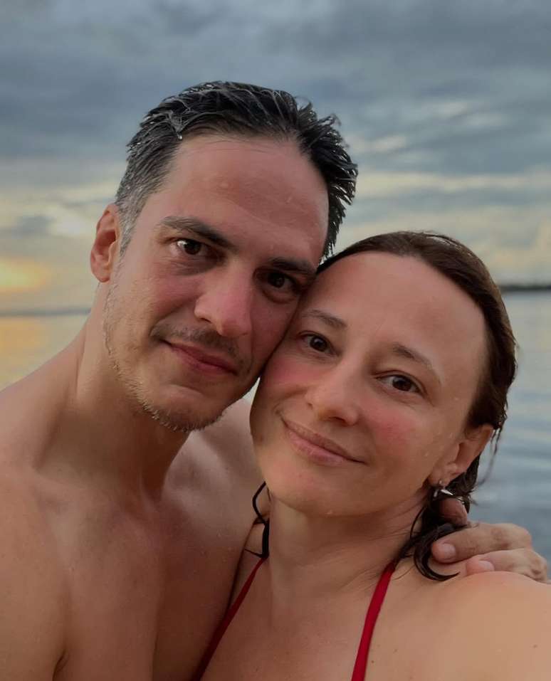 Mateus Solano and Paula Braun pose with the sea in the background