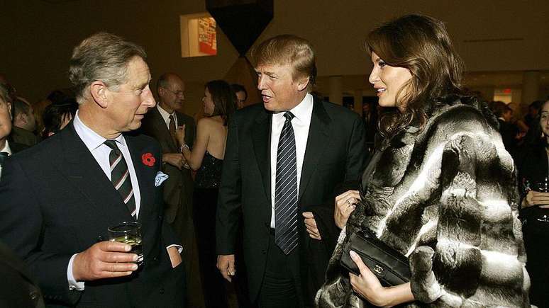 Donald Trump e sua esposa Melania conversam com o rei, então conhecido como príncipe Charles, durante uma recepção no Museu de Arte Moderna em 2005