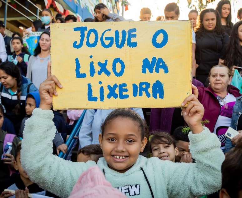 A caminhada pela comunidade tem cartazes, carro de som, distribuição de mudas e envolvimento coletivo.
