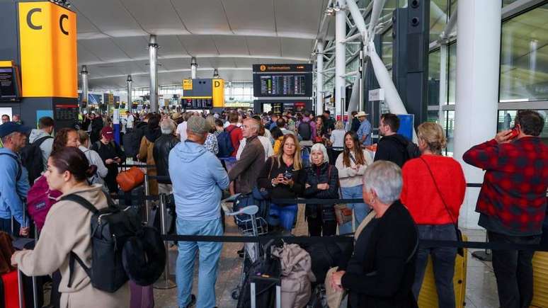 Os viajantes em Heathrow relatam atrasos de várias horas e longas filas no check-in.