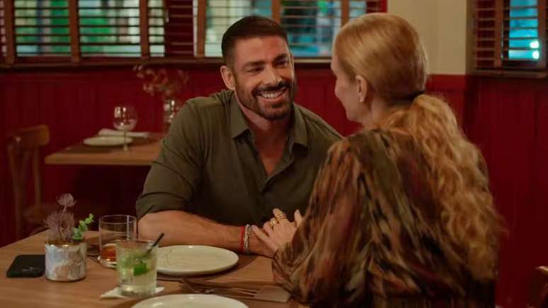 César (Cauã Reymond) no cenário do restaurante: os lambris vermelhos são inconfundíveis