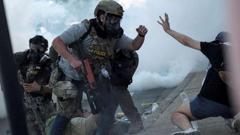 Agentes federais e do ICE em confronto com manifestantes contra prisões de estrangeiros, em Chicago, em 4 de outubro de 2025.