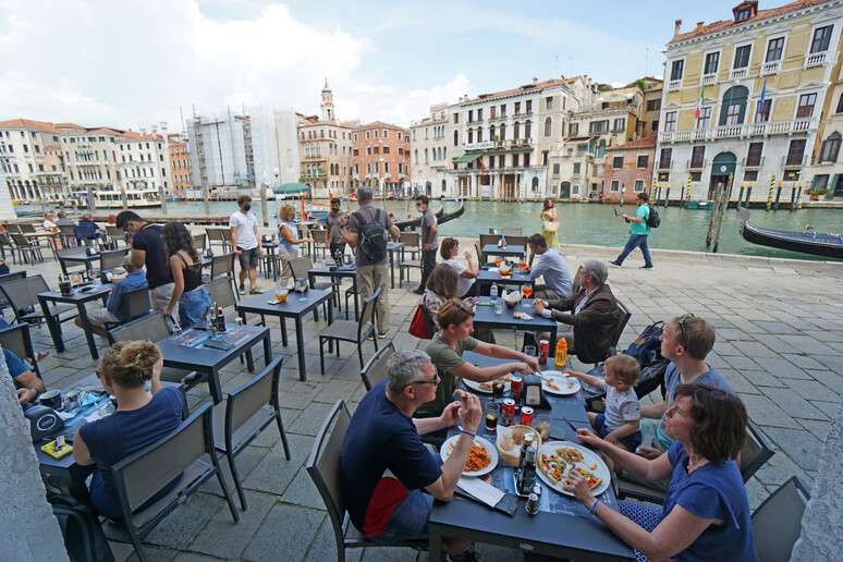 Turistas em bar em Veneza, joia turística da Itália