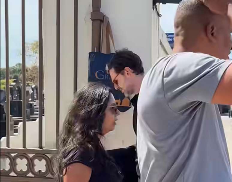 Guilherme Magon saindo de cemitério durante gravação de 'Vale Tudo'