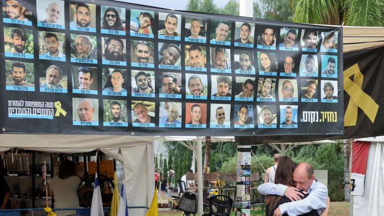 Israelenses se abraçam na “praça dos reféns”, após o anúncio de que Israel e o grupo Hamas haviam chegado a um acordo sobre a primeira fase de um cessar-fogo em Gaza, em 9 de outubro de 2025.