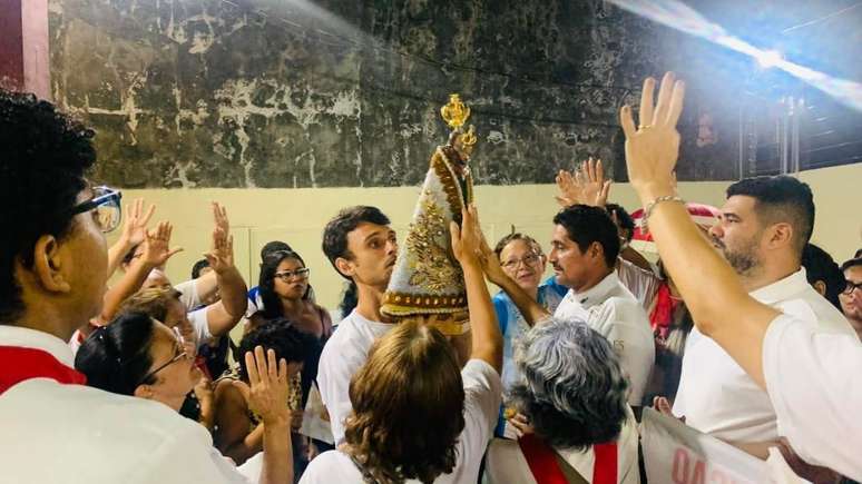  Grupo de oração no bairro de Castanheira, organizado pelo guia de turismo religioso Renan Ribeiro, no centro da foto.