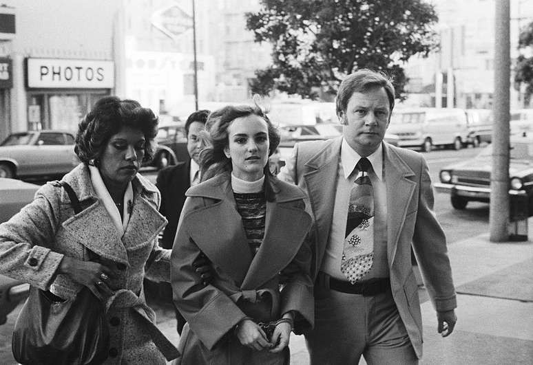 Patty Hearst é levada ao seu julgamento em 1976 por dois agentes federais