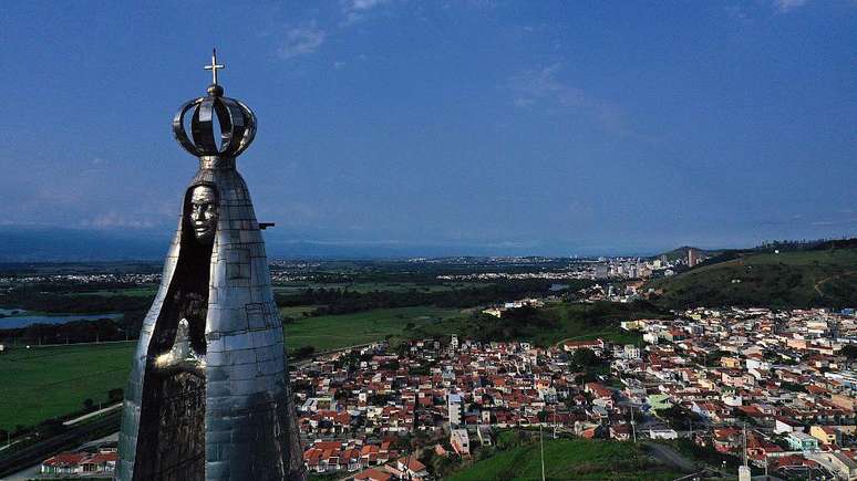 Uma estátua de 50 metros de altura de Nossa Senhora Aparecida, com a cidade de Aparecida ao fundo