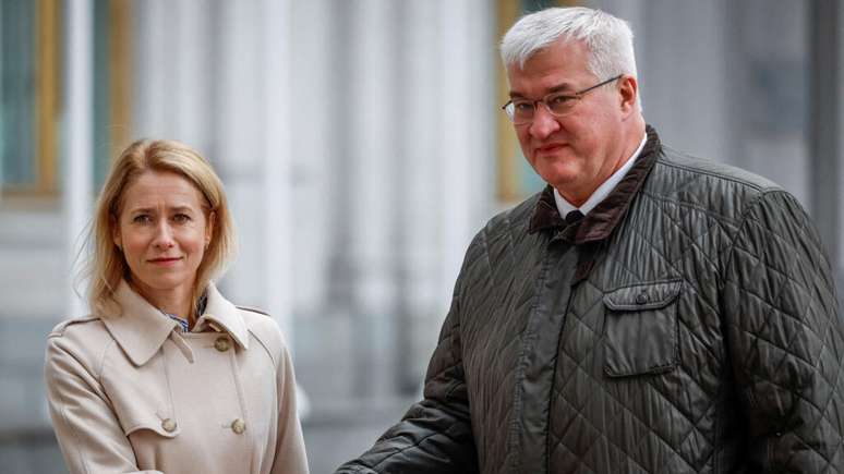 O ministro das Relações Exteriores da Ucrânia, Andrii Sybiha, e a alta representante da União Europeia para Assuntos Externos e Política de Segurança, Kaja Kallas, apertam as mãos antes de uma coletiva de imprensa conjunta, em meio ao ataque da Rússia contra a Ucrânia, em Kiev, nesta segunda (13).