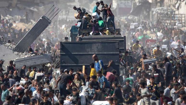 Palestinians receive supplies from a humanitarian aid truck that arrived in Khan Younis, in the southern Gaza Strip
