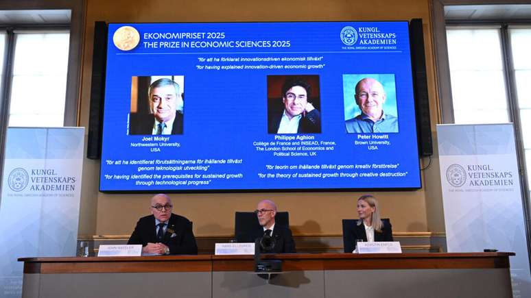 O secretário-geral da Real Academia Sueca de Ciências, Hans Ellegren (C), discursa para jornalistas, durante o anúncio do vencedor do Prêmio Nobel de Economia de 2025. Em Estocolmo, em 13 de outubro de 2025.