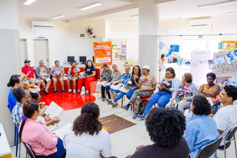 Turma reunida para leitura na Maré. Atualmente, estão lendo Redemoinho em Dia Quente, de Jarid Arraes.