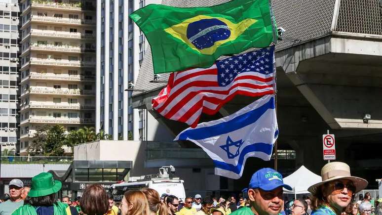 Na Avenida Paulista, manifestantes carregam bandeiras do Brasil, Estados Unidos e Israel, em ato em agosto convocado por aliados de Bolsonaro