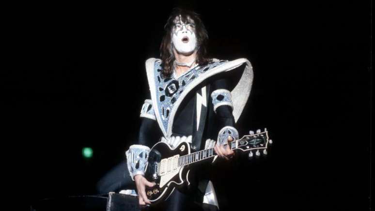 Ace Frehley, com sua maquiagem preta e branca característica do KISS, tocando guitarra