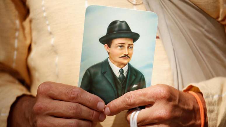 Homem segura imagem de José Gregorio Hernández durante cerimônia de beatificação do médico em Caracas, em 30 de abril de 2021.