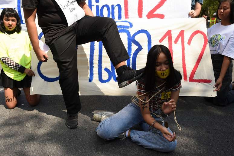 Um manifestante antigoverno durante com&iacute;cio pedindo a revoga&ccedil;&atilde;o da Se&ccedil;&atilde;o 112 do C&oacute;digo Penal tailand&ecirc;s, que criminaliza insultos ao monarca