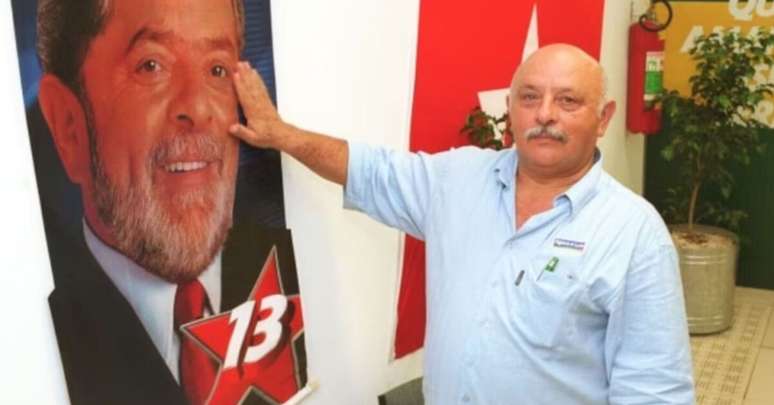 Frei Chico, irmão e Lula, ao lado da bandeira do presidente. 