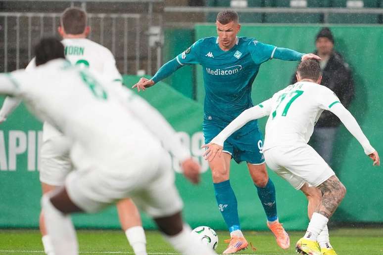 Edin Dzeko em disputa de bola com defensores do Rapid Wien &ndash;