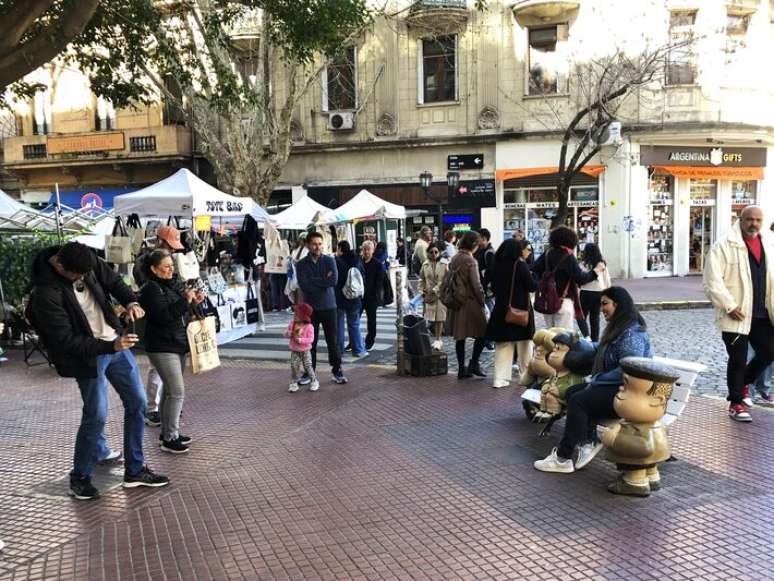 Turistas tiram foto com a est&aacute;tua da Mafalda na Feira de San Telmo