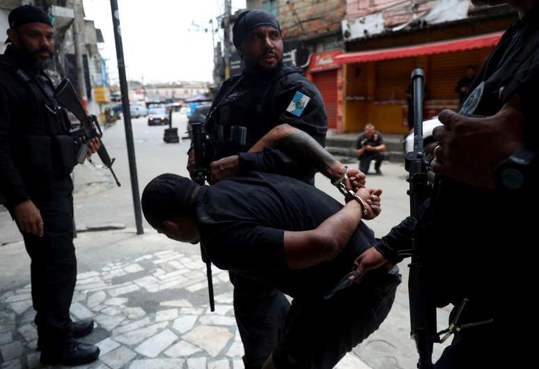 Imagem de um homem detido por agentes da pol&iacute;cia durante a opera&ccedil;&atilde;o policial na favela da Penha, no Rio de Janeiro, nesta ter&ccedil;a-feira, 28