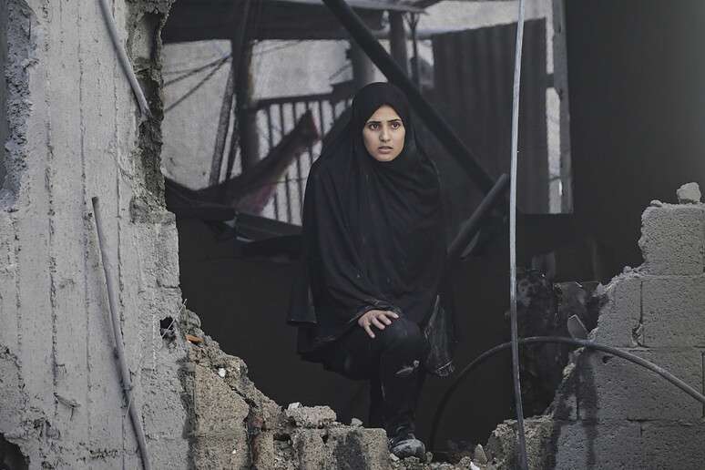 Mulher em meio a destroços de prédio bombardeado por Israel em campo de refugiados