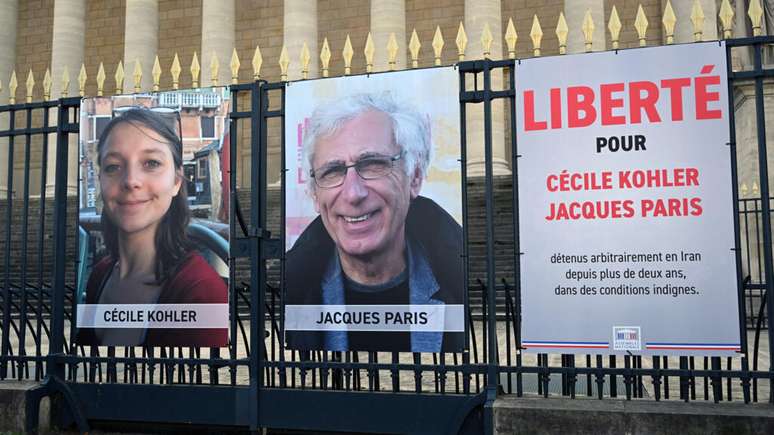Faixa com os dizeres “Liberdade para Cécile Kohler e Jacques Paris, detidos arbitrariamente no Irã há mais de dois anos em condições deploráveis”, em frente à sede da Assembleia Nacional da França, em 25 de março de 2025.