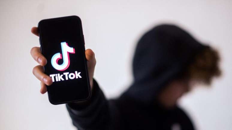 Adolescente mostra um smartphone com a logomarca do Tik Tok. A rede social é investigada na França por suspeita de incentivar o suicídio de jovens.