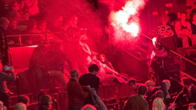 Imagem de vídeo mostra o momento em que um ativista pró-palestino acende um rojão na plateia da Filarmônica de Paris durante o concerto da Orquestra de Israel nesta quinta-feira, 6 de novembro de 2025.