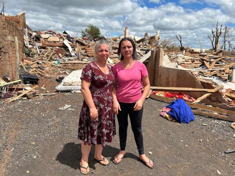A aposentada Luiza Velozo e sua filha Fabíola dos Santos, em frente ao que restou da casa de Luiza