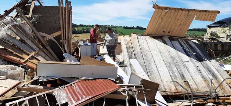 Ronaldo Silva and Ludicia dos Santos amid the ruins of the house destroyed by the hurricane in the Cohabar neighborhood, in Rio Bonito do Iguaçu.