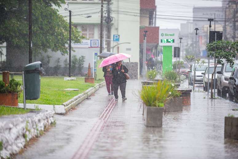 Pedestrians shelter from the rain in Venancio Aires, Rio Grande do Sul, this Friday (7th) as an extratropical cyclone passes through the area. The state is on alert for heavy rain and gusty winds.