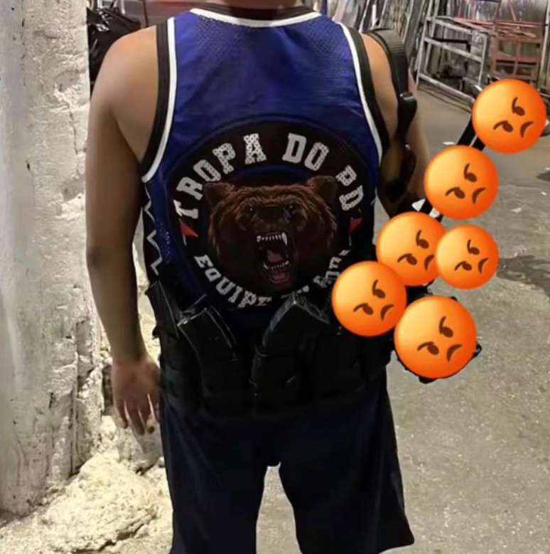 Jovem posa para foto com o que parece ser uma arma nas costas e camiseta da Tropa do Urso, grupo ligado ao traficante Doca, do Comando Vermelho