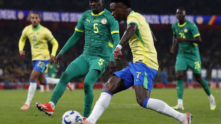 O meio-campista do Senegal, camisa 5, Idrissa Gana Gueye, disputa a bola com o meio-campista do Brasil, camisa 7, Vinicius Jr, durante a partida amistosa internacional entre Brasil e Senegal no Emirates Stadium, em Londres, em 15 de novembro de 2025.