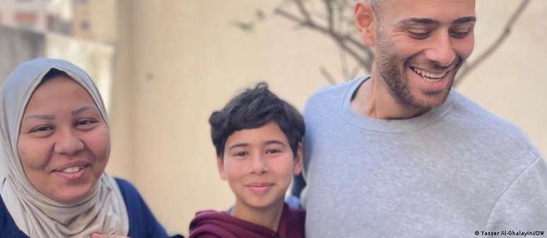 Yasser Al-Ghalayini (36) sorri com a mulher, Wajiha (31), e o filho Amman (11) após voltar para casa na Cidade de Gaza