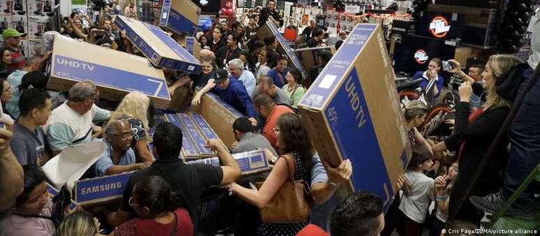 Consumidores disputando televisores na Black Friday