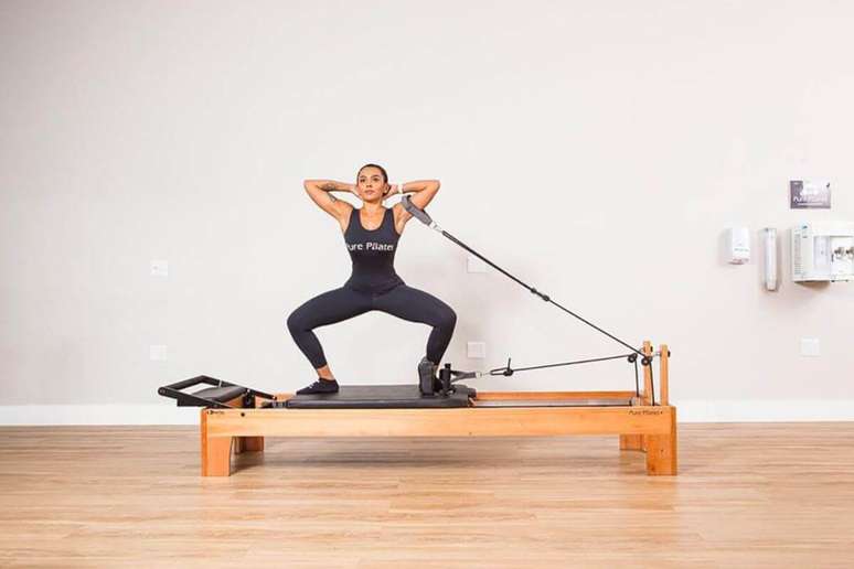 రిఫార్మర్‌పై సుమో స్క్వాట్‌లు హిప్ జాయింట్ ఫ్లెక్సిబిలిటీని మెరుగుపరచడంలో సహాయపడతాయి 