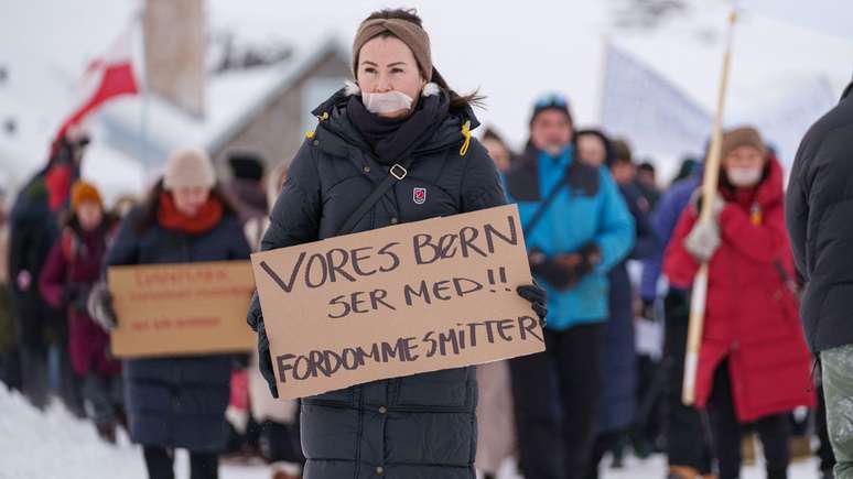 Uma manifestante segura um cartaz com os dizeres: "Nossos filhos est&atilde;o observando!! Preconceitos s&atilde;o contagiosos", durante uma manifesta&ccedil;&atilde;o em Nuuk, capital da Groenl&acirc;ndia, no in&iacute;cio deste ano