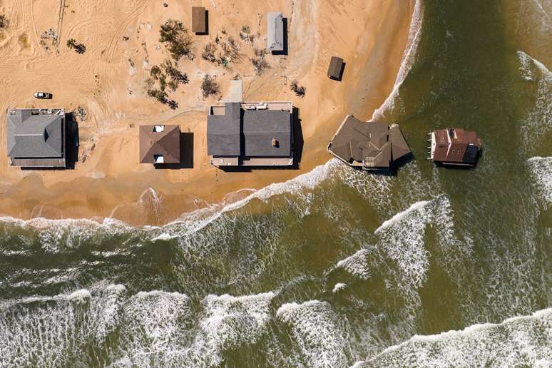 Aumento do nível do mar altera as linhas costeiras, colocando casas e populações em risco: muitos lugares experimentam uma elevação superior à média global, enquanto lugares próximos à camada de gelo podem até ver o nível do mar baixar, e a principal razão tem a ver com a gravidade. Aerial Views/E+/Getty Images