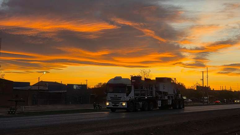 Caminh&atilde;o trafegando na estrada ao entardecer