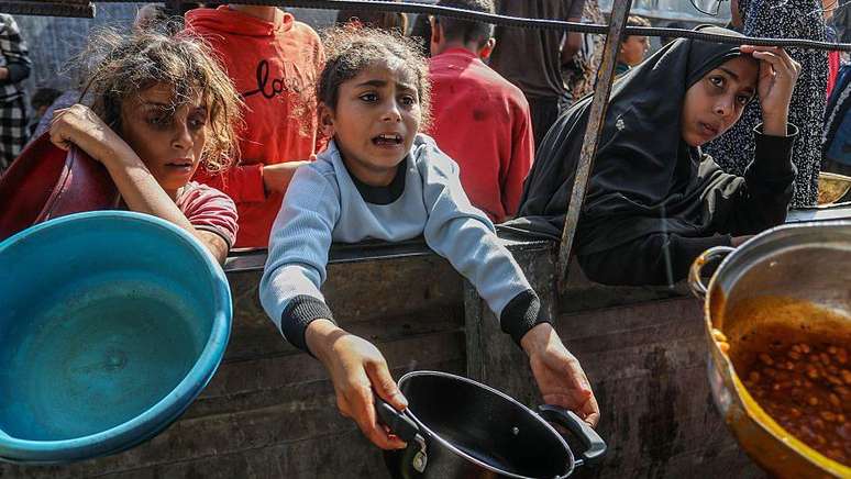 Meninas aguardando para receber alimentos em 27 de novembro em um ponto de distribuição em Gaza