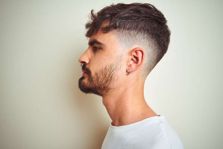 O corte médio texturizado e a barba curta alinhada equilibram estilo e praticidade 